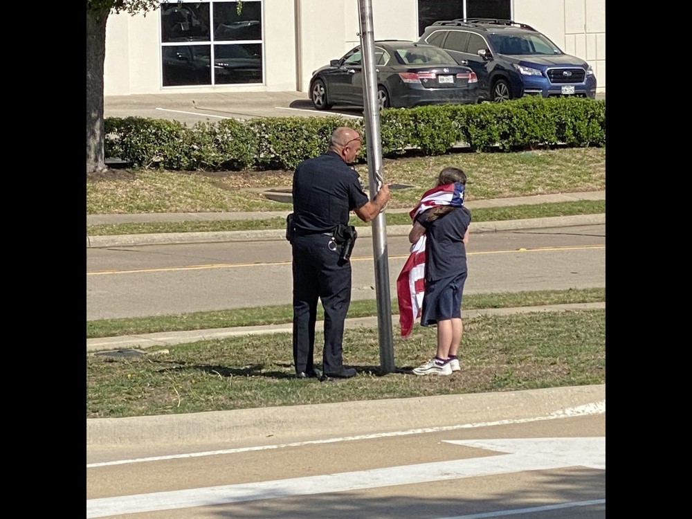 Officer and Student lowering flag