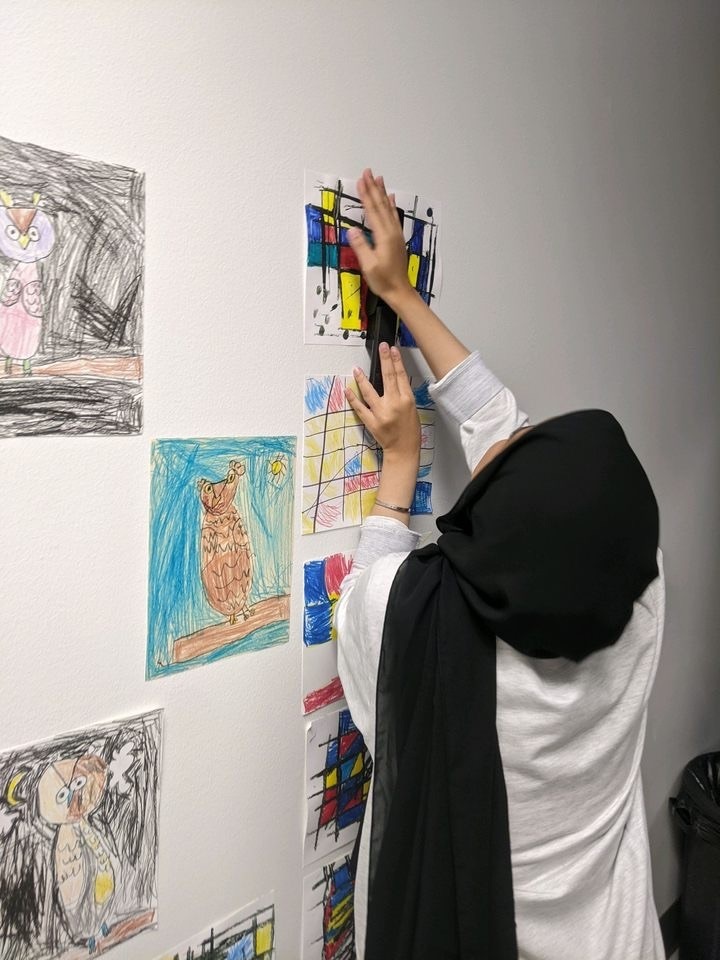 child hanging art work